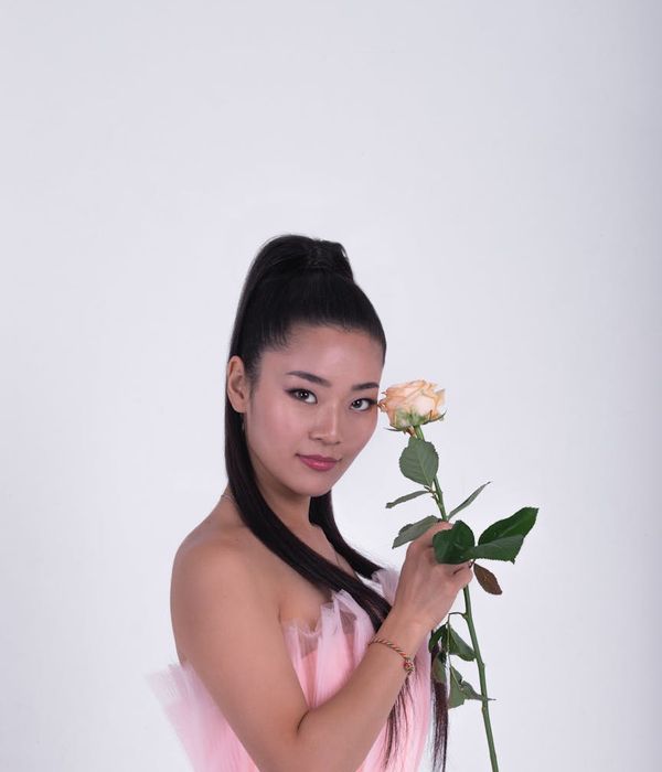 Woman in a calm yoga pose in a dark studio with lime green light.